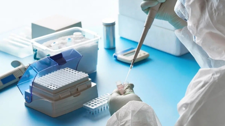 Laboratory researcher using pipette for multi omics drug discovery analysis